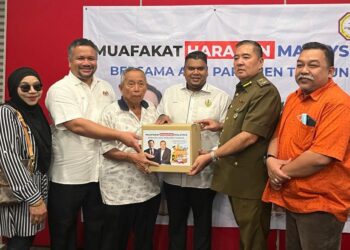 MUHAMAD Arafat Varisai Mahamad (tiga dari kanan) menyampaikan bantuan makanan kepada penerima di Pusat Khidmat Ahli Parlimen Tambun di Ipoh hari ini. - UTUSAN/LIYANA RAMLI