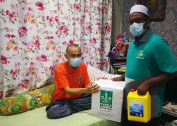 TIMBALAN Setiausaha Perkim Kapar, Muhammad Raihan Ibrahim Muniandy (kanan) menyampaikan sumbangan kepada Mohd. Nasir Zakaria di rumahnya di Kampung Rantau Panjang di Klang, Selangor. - FOTO/ABDUL RAZAK IDRIS