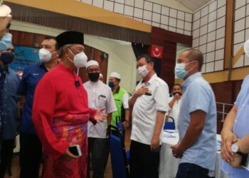 MUHYIDDIN Yassin (kiri) beramah mesra ketika menghadiri Majlis Perjumpaan Bersama Pimpinan Tempatan di Dewan Serbaguna Bukit Gambir, Tangkak, Johor. - FOTO/NUR ALINA HASSAN