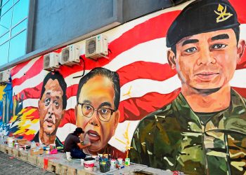 SEORANG pelukis menyiapkan mural yang diubah daripada false colour kepada teknik biasa di Kuantan, Pahang, semalam. – UTUSAN/AJIE MUSTAFA