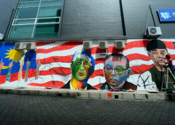 AHMAD Fadzril Abdul Ruzsnan gigih menyiapkan lukisan mural pada dinding bangunan sebuah klinik pergigian swasta di Kuantan, Pahang, semalam. – UTUSAN/AJIE MUSTAFA