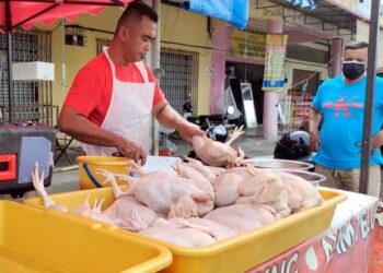 MOHD. Redhwan Kamaruddin menyiapkan tempahan ayam pelanggan ketika ditemui di gerai ayamnya di Sikamat, Seremban semalam.-UTUSAN/ZAKKINA WATI AHMAD TARMIZI