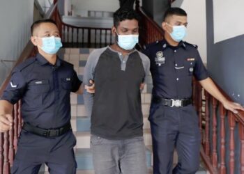SEORANG penganggur, Kamaluddin Lukman yang mengaku tidak bersalah mengugut bunuh bapa dan abang kandungnya diiringi anggota polis di Mahkamah Majistret di Ayer Keroh, Melaka hari ini. - UTUSAN/RASUL AZLI SAMAD