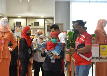 M. Zambri Mahmud (kanan) mengedarkan risalah Kempen Kesedaran Pencegahan Jenayah Komersial kepada pengunjung di KTCC Mall di Kuala Terengganu, hari ini. - TENGKU DANISH BAHRI TENGKU YUSOFF
