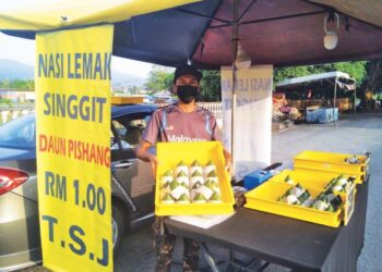 ZULKIFLI Nordin menunjukkan nasi lemak RM1 yang dijual berdekatan Balai Bomba Jerantut di bandar Jerantut, Pahang. - UTUSAN/HARIS FADILAH AHMAD