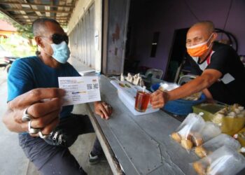 AZMI Yusoff menunjukkan sijil sudah lengkap dua dos vaksin bagi membolehkan dia bersarapan di sebuah warung di Kampung Kubang Labu, Wakaf Bharu, Tumpat semalam. - UTUSAN/ZULHANIFA SIDEK