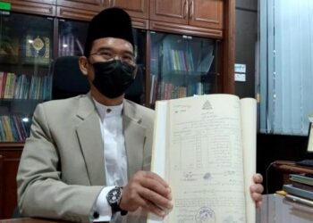 MOHD. Fauzi Bachok menunjukkan buku rekod pernikahan penduduk Segamat pada bulan Ogos 1957 yang kini berada dalam simpanan Pejabat Kadi Segamat di Johor.