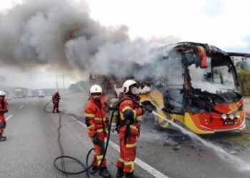 Pasukan bomba memadamkan kebakaran sebuah bas persiaran yang mengalami kerosakan enjin di Kilometer 279.3 Lebuh Raya Utara Selatan arah Utara dekat Nilai, Seremban, semalam.