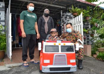 NORLIYANA Ismail dan suaminya, Aizul Izan Adenan melihat anak mereka, Muhammad Yusuf menaiki jentera kecil bomba ditemani Penolong Penguasa Bomba, Faizal Ahmad di Taman Eka Matahari, Bandar Enstek, Seremban, semalam. – FOTO/ZAKKINA WATI AHMAD TARMIZI