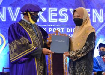 MOHLIS Jaafar (kiri) menyampaikan Diploma Kejuruteraan Awam kepada Habibah yang mewakili arwah anaknya pada Majlis Konvokesyen Politeknik Port Dickson Ke-29 di Port Dickson hari ini. - FOTO/ZAKKINA WATI AHMAD TARMIZI