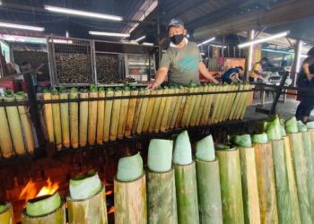 NORIZAN Talib membakar lemang di gerai jualannya yang terletak di Jalan Jelebu, Ampangan, Seremban hari ini. - FOTO/BADRUL HAFIZAN MAT ISA