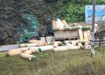 SEBUAH lori yang membawa muatan 90 tong gas amonia terbalik di jalan utama Sungai Timun-Lubuk China, Rembau, pagi tadi. - FOTO/NOR AINNA HAMZAH