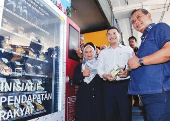 RAFIZI Ramli (tengah) dan Aminuddin Harun (kanan) mencuba mesin layan diri ketika mengadakan lawatan ke tapak Mesin Layan Diri Inisiatif Pendapatan Rakyat (IPR) di Stesen Bas Terminal 1 Seremban, Seremban, semalam. – FOTO/MOHD. SHAHJEHAN MAAMIN