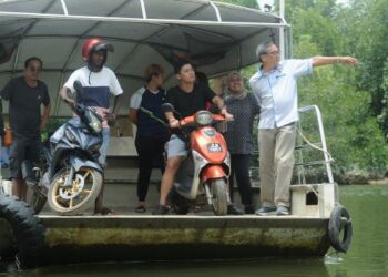 YEK Diew Ching (kanan) bersama penduduk menggunakan perkhidmatan bot penambang untuk menyeberang Sungai Sepang di Port Dickson dan Sungai Pelek, Selangor. – FOTO/MOHD. SHAHJEHAN MAAMIN