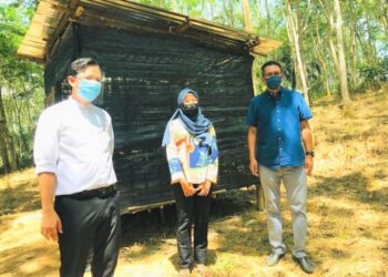 Pengarah SKMM negeri, Mohd. Khairilnaim Osman (kiri) dan Saiful Yazan Sulaiman (kanan) menemui Mimi Izmaliza yang mengikuti PdPR bersama adiknya di sebuah pondok di dalam kebun getah di Kampung Malan, Dangi, Kuala Pilah baru-baru ini