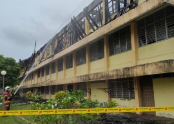 ANGGOTA bomba memadamkan kebakaran yang berlaku membabitkan bangunan asrama pelajar lelaki di SMKA Dato' Haji Abu Hassan Haji Sail, Pedas, Rembau petang kelmarin.-UTUSAN/NOR AINNA HAMZAH.
