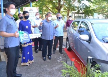 AMINUDDIN Harun (tengah) bersama pemenang hadiah utama Cabutan Bertuah Cukai Taksiran MPPD 2021, Nor Farhanis Shamsuddin (dua dari kiri) dalam majlis yang diadakan di Dewan MPPD Port Dickson hari ini. - FOTO/ZAKKINA WATI AHMAD TARMIZI