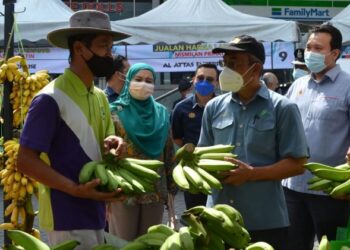 BAKRI Sawir (tengah) mengadakan lawatan ke gerai agro tani muda perniagaan pisang, Hairul Afzan Mohamed Rais, 40, pada  Program Jualan Harga Ladang Nismilan Prihatin di Seremban hari ini. - FOTO/ZAKKINA WATI AHMAD TARMIZI