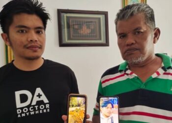 MOHD. Yazid Mohd. Nor dan anak sulungnya, Muhammad Ikmal, 29, menunjukkan gambar pokok yang tumbang di lokasi kejadian dan gambar Allahyarham Muhammad Ikram ketika ditemui di rumahnya di Kampung Baru Perigi Jernih, Rembau hari ini. - FOTO/NOR AINNA HAMZAH