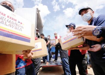 ANNUAR Musa (tengah) turun padang membantu mangsa banjir, baru-baru ini. – UTUSAN/MOHD. SHAHJEHAN MAAMIN