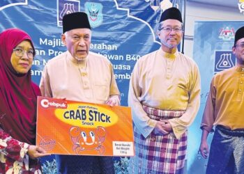 PENGERUSI MAINS, Datuk Seri Dr. Abdul Aziz Sheikh Abdul Kadir (dua dari kiri) menyerahkan replika pembungkusan kepada usahawan snek jejari ketam, Norlaila Shafiei pada Majlis Penyerahan Pembungkusan Produk Usahawan B40 dan Asnaf dan Majlis Berbuka Puasa di Seremban, semalam. - FOTO/ZAKKINA WATI AHMAD TARMIZI