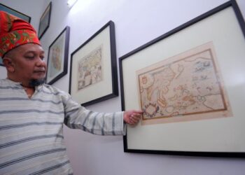 WAN Ahmad Arshad menunjukkan peta Ortelius yang dimilikinya ketika ditemui Utusan Malaysia di rumahnya di Taman Tasik Jaya, Seremban, kelmarin.-UTUSAN/MOHD. SHAHJEHAN MAAMIN.