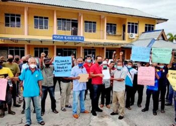 NELAYAN mengangkat sepanduk membantah pencerobohan nelayan tidak berdaftar dan penangkapan siput di perairan Kuala Perlis di kompleks LKIM, Kuala Perlis, Perlis hari ini.- UTUSAN/SYED AZLAN SAYID HIZAR