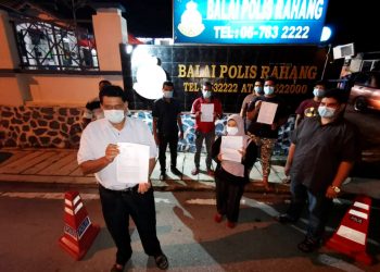 MOHD. Rofik Mohd. Yusof (depan) menunjukkan laporan polis yang dibuat pihaknya di Balai Polis Rahang, dekat sini, malam semalam.-UTUSAN/AFIFI HAFIZ MOHD NOR