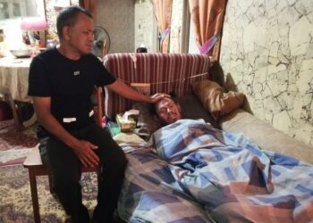 MADRIS Manap bersama anaknya, Muhammad Haffendi yang kini terlantar akibat sakit kulit yang dihadapinya sejak dua tahun lalu ketika ditemui Utusan Malaysia di Pangsapuri Rakyat Seri Perdana Paroi, Seremban, semalam. - UTUSAN/ZAKKINA WATI AHMAD TARMIZI
