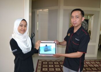 NUR 'Aisyaa Syafiqah Shuhaimi bersama guru pembimbing, Mohd. Nurhafiz Aman Shah menunjukkan reka bentuk mesin prototaip UCOnverter ketika ditemui Utusan Malaysia di Bandar Baru Enstek, Nilai, Seremban, semalam. - FOTO/ZAKKINA WATI AHMAD TARMIZI