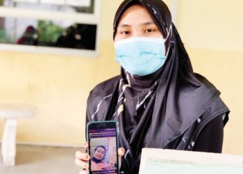 NUR Syahirah Abdullah menunjukkan foto terakhir Mohd. Nur Hisham Hassan yang dihantar kepadanya sebelum suaminya itu maut dalam kemalangan di  Kilometer 4, Jalan Sitiawan - Kampung Acheh di Sitiawan, semalam. – UTUSAN/SHAMSUL KAMAL AMARUDIN