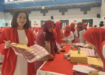 NIK Suryani Megat Deraman (kiri) mengambil kertas undi pemilihan jawatankuasa Wanita UMNO Pusat dan Bahagian Marang pada Mesyuarat Perwakilan Wanita UMNO bahagian itu di Bukit Payung, Marang, hari ini.