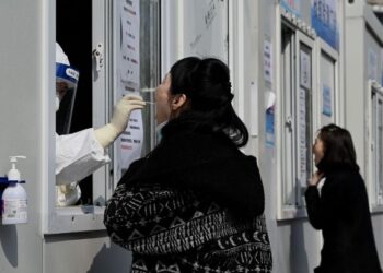 PETUGAS kesihatan melakukan ujian swab untuk mengesan Covid-19 di sebuah pusat kesihatan di Beijing, China. - AFP