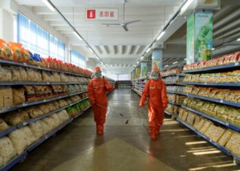 PEKERJA melakukan kerja-kerja sanitasi sebagai langkah pencegahan Covid-19 di sebuah pasar raya di Pyongyang. - AFP