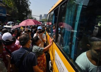 AHLI keluarga mengerumuni bas yang membawa banduan di luar penjara Insein selepas dibebaskan di Yangon. -AFP