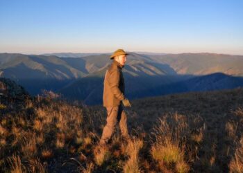 VLADIMIR Putin berjalan di padang rumput berlatarbelakangkan pemandangan gunung. - AFP