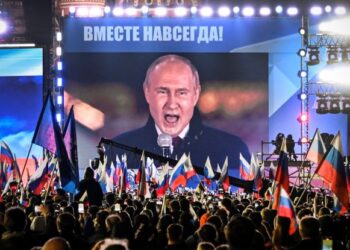 VLADIMIR Putin berucap sambil disaksikan orang ramai menerusi skrin video besar secara langsung di Dataran Merah di Moscow. - AFP