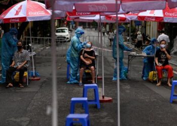 PETUGAS kesihatan melakukan ujian saringan Covid-19 terhadap penduduk di Old Quarter di Hanoi pada 11 Ogos lalu. - AFP