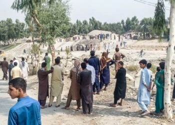 ANGGOTA Taliban dan orang awam berkumpul di sebuah lokasi kejadian letupan yang menyasarkan trak di Jalalabad, Afghanistan. - AFP
