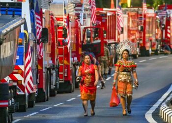 KUALA LUMPUR, Dua orang wanita berpakaian tradisional melewati deretan kenderaan milik Jabatan Bomba dan Penyelamat Malaysia (JBPM) dan MARITIM Malaysia pada raptai penuh perbarisan Sambutan Hari Kebangsaan Malaysia 2022 di Dataran Merdeka.UTUSAN/MUHAMAD IQBAL ROSLI