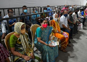 PENDUDUK menunggu giliran untuk menerima suntikan vaksin Covid-19 di sebuah pusat vaksinasi di Mumbai. - AFP