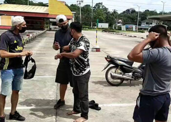 MONG FIEW ditahan oleh polis di luar sebuah kedai serbaneka di daerah Sadao, Songkhla. - AGENSI