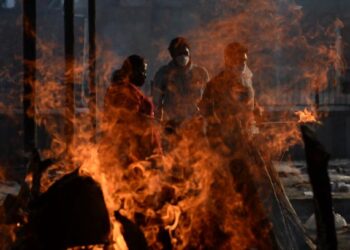 BEBERAPA ahli keluarga kepada pesakit Covid-19 yang meninggal dunia berada di sebuah pusat pembakaran mayat di New Delhi. - AFP