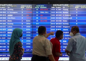 SEPANG 27 JULAI 2022, Sebahagian orang ramai melihat skrin maklumat penerbangan terkini selepas Lapangan Terbang Antarabangsa Kuala Lumpur (KLIA) turut terjejas berikutan bekalan elektrik terputus seketika di sini, hari ini. UTUSAN/FAISOL MUSTAFA