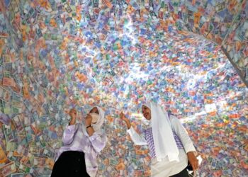 KUALA LUMPUR 25 Ogos 2022, Aida Syahirah Osman (kanan) bersama Alysha Khaireen Shaifutra (kiri) teruja melihat helaian wang pelbagai nilai keluaran Bank Negara Malaysia yang dijadikan Terowong Sejuta Ringgit di Muzium & Galeri Seni Bank Negara Malaysia.UTUSAN/FAUZI BAHARUDIN