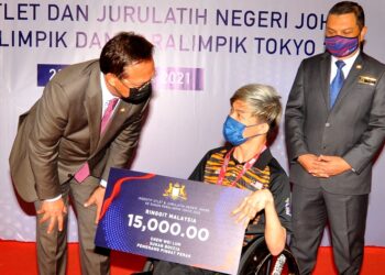 HASNI Mohammad menyampaikan hadiah insentif berjumlah RM15,000 kepada Chew Wei Lun yang meraih pingat perak dalam Sukan Paralimpik Tokyo 2020 ketika majlis penyampaian di Kota Iskandar, Johor. -UTUSAN/RAJA JAAFAR ALI