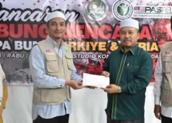 AHMAD Yahaya (kanan) menyerahkan sumbangan bantuan kepada PASRelief dalam satu majlis semalam.