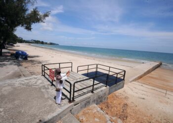 SEORANG pengunjung merakamkan gambar sekitar Pantai Telok Kemang yang lengang ekoran pelaksanaan PKP di seluruh negara serta penguatkuasaan larangan rentas daerah dan negeri bagi mengekang penularan Covid-19.- UTUSAN//MOHD. SHAHJEHAN MAAMIN