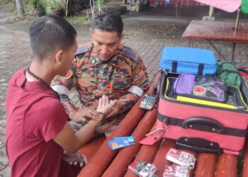 ANGGOTA bomba memberi rawatan awal kepada mangsa yang terselamat selepas bot dinaiki terbalik di Sungai Perak berhampiran Jeti Dataran Udang Galah, Teluk Intan hari ini. - UTUSAN/IHSAN JBPM