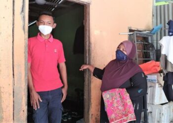 PASANGAN ibu dan anak dari Sungai Baru, Che Muni Che Lah (kanan) dan Muhd. Fiqdaus Iqmal Zubir gembira pembangunan PSR juga memberi peluang latihan kepada nelayan dan anak nelayan.